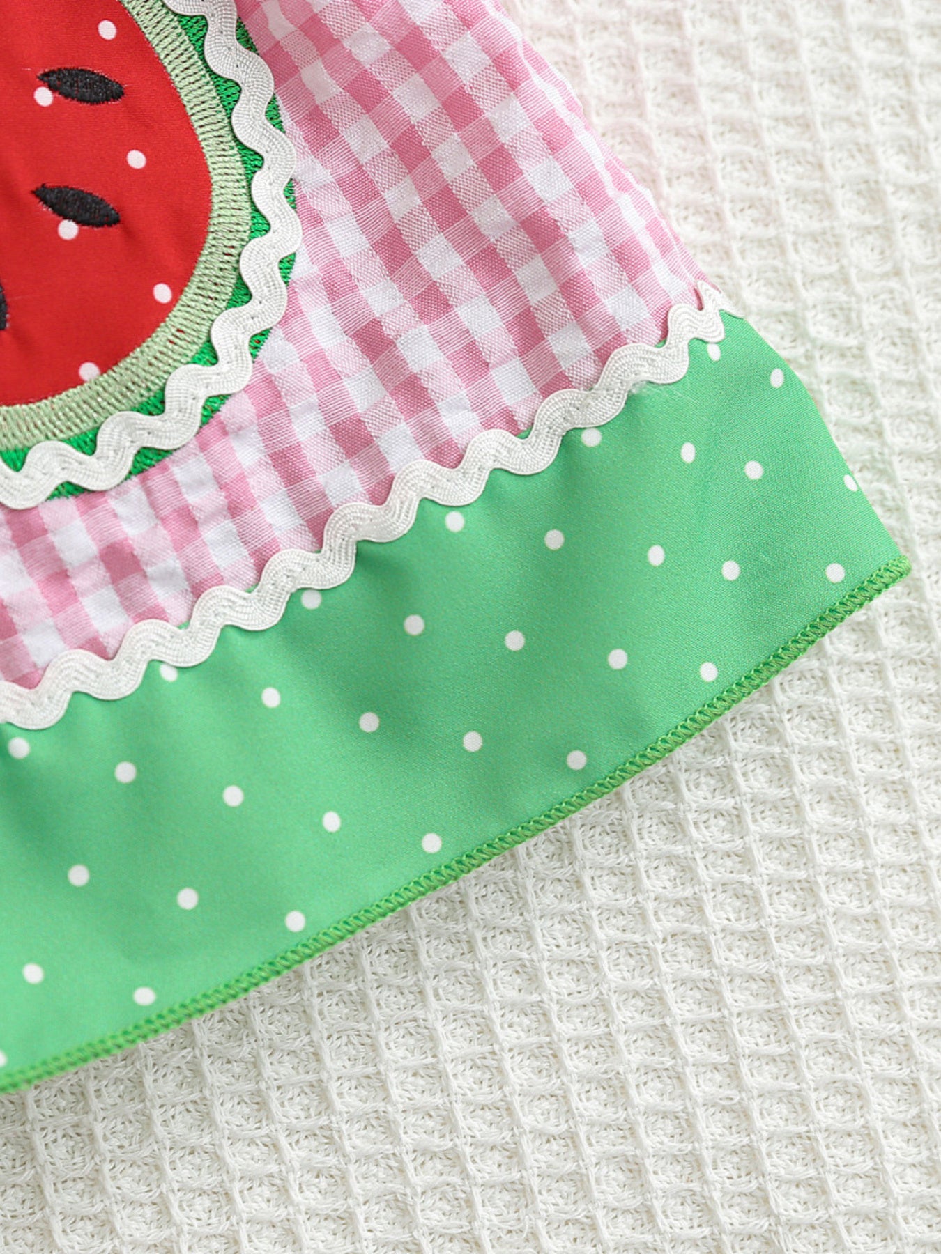 Baby dress with pink gingham, watermelon pocket, green polka dot hem, and white trim.