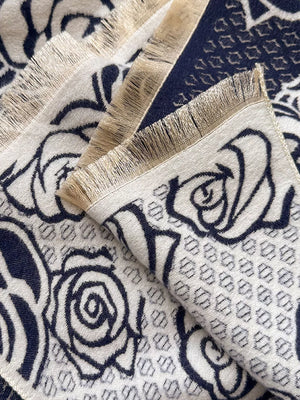 Elegant floral pattern scarf in black and white with fringed edges.