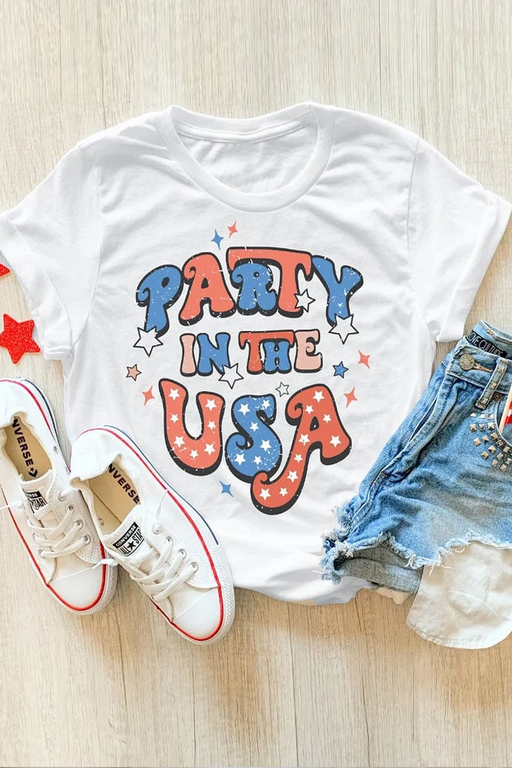 White t-shirt with retro "Party in the USA" graphic in red, white, and blue stars and lettering.