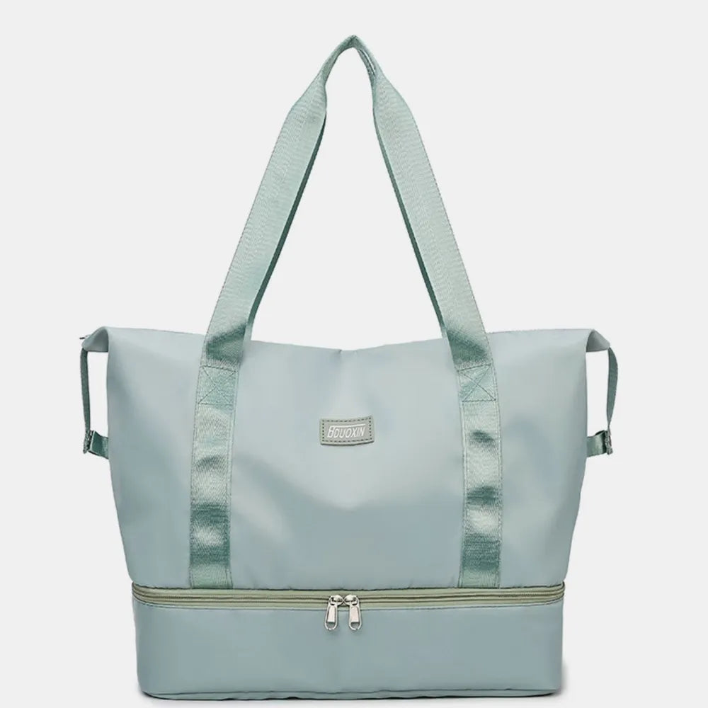 Pale blush dual-compartment travel tote with metallic trim and dual zippers.