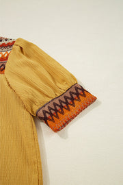 Mustard blouse with embroidered yoke and puff sleeves.