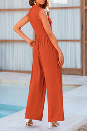 Ribbed mock neck jumpsuit in burnt orange with wide legs and a cinched waist.