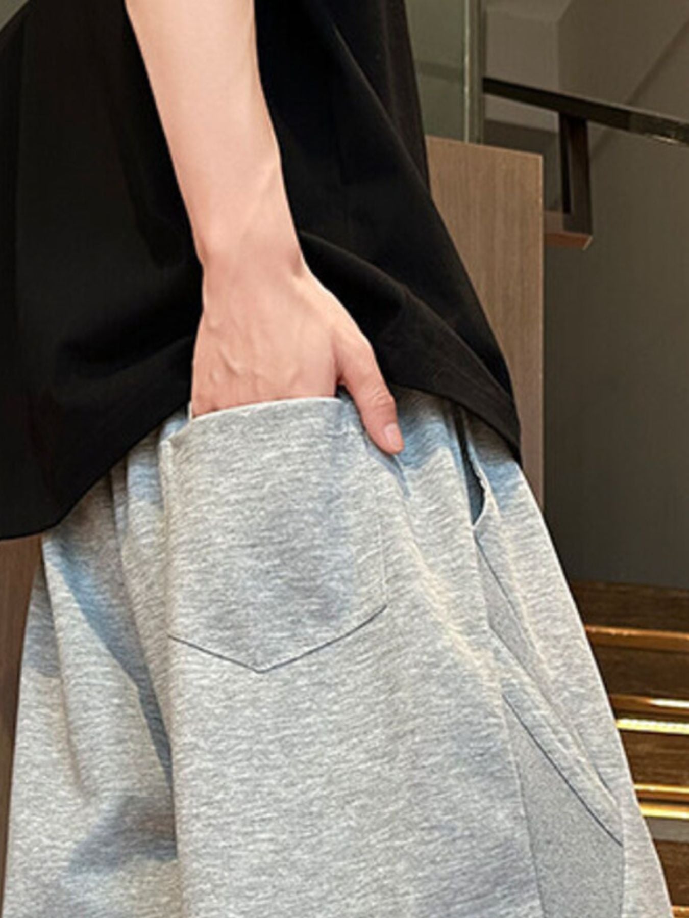 Men's light gray drawstring shorts with a back pocket detail.