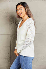 White diamond knit button-down cardigan with open knit sleeves and gold buttons.