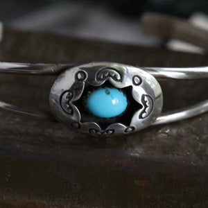 Turquoise cuff bracelet with intricate silver detailing and a central aqua stone.