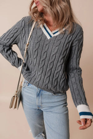 Dark gray cable knit sweater with v-neck and varsity trim on collar and cuffs.