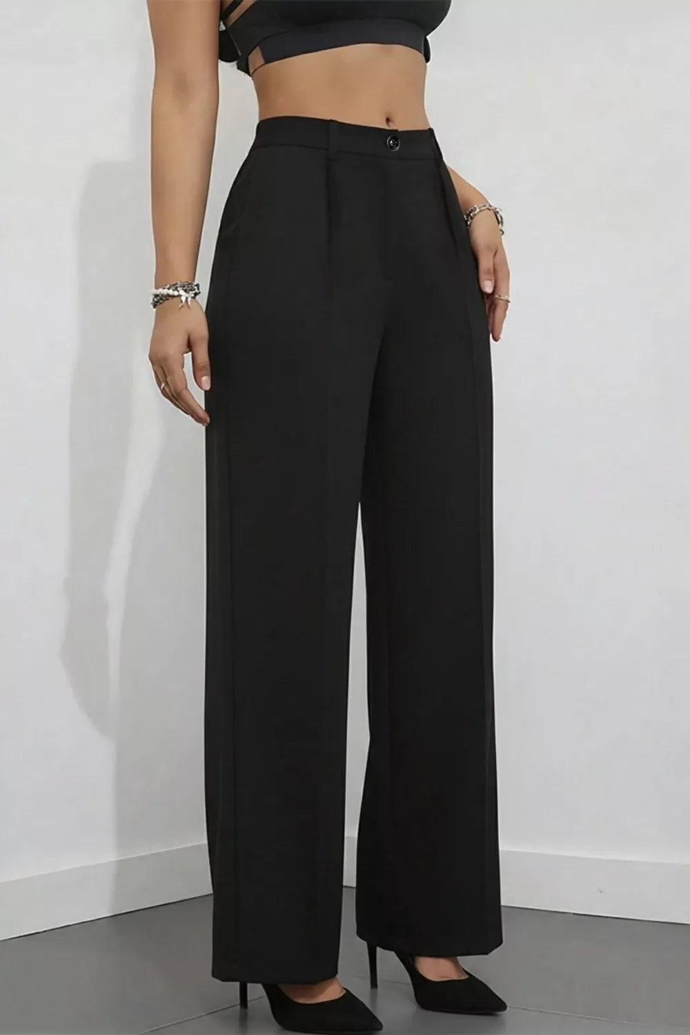 Black high-waisted wide-leg trousers with a button closure and pleat detail.