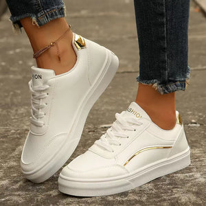 White sneakers with gold metallic trim and accents.