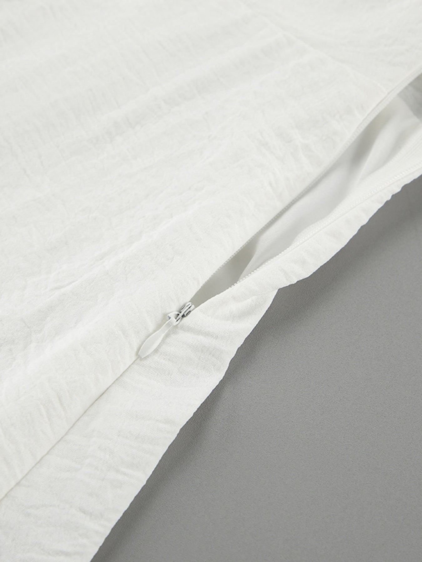 White off-shoulder midi dress with textured fabric and side zipper detail