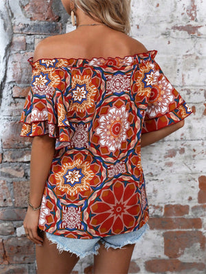 Bohemian off-shoulder blouse with ruffled sleeves and a bold geometric print in terracotta.
