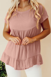 Dusty pink textured peplum top with ruffle hem and short sleeves.