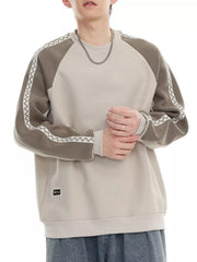 Oversized sweatshirt in beige with gray raglan sleeves featuring white zigzag stitching detail.