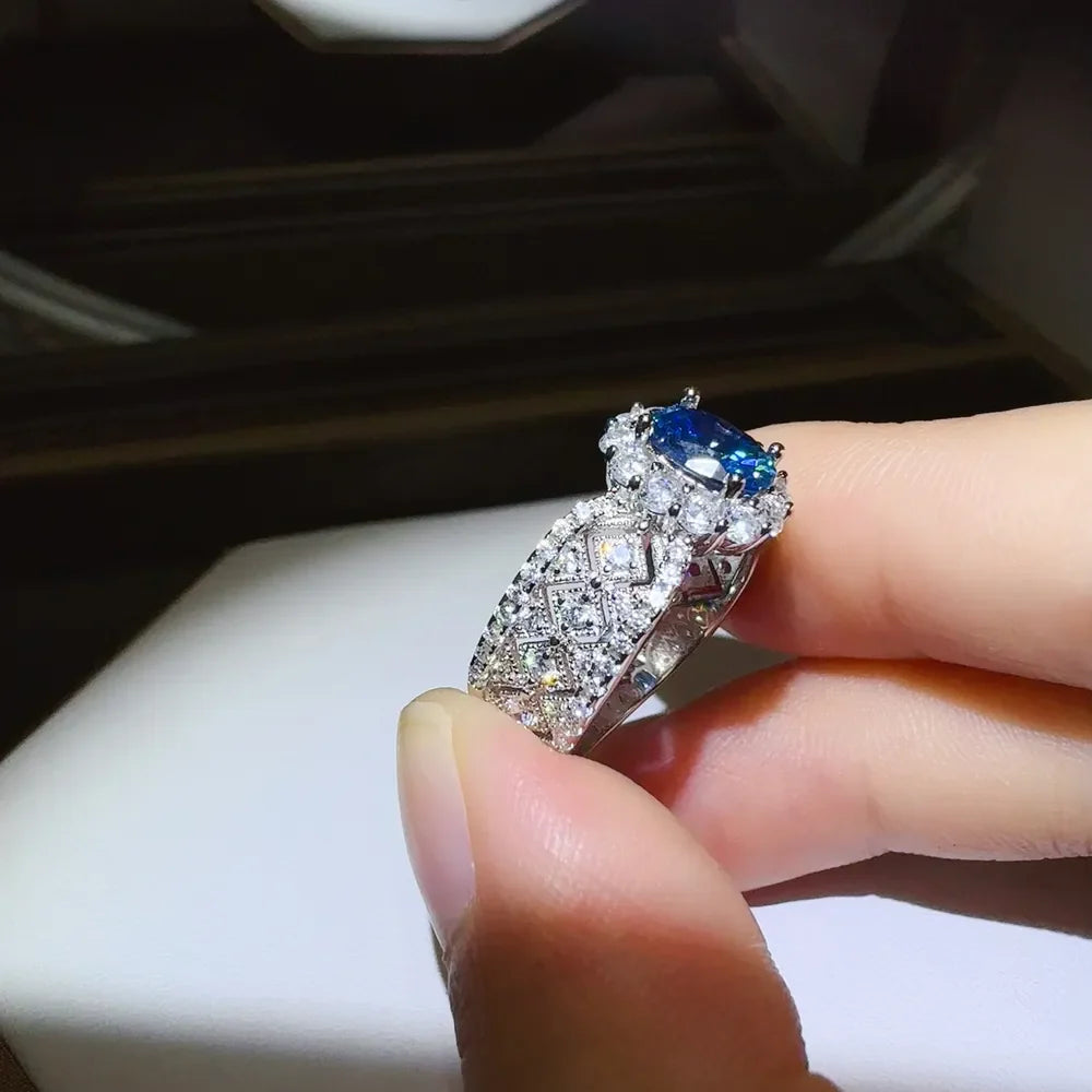 Silver ring with blue oval gemstone and diamond halo on textured band