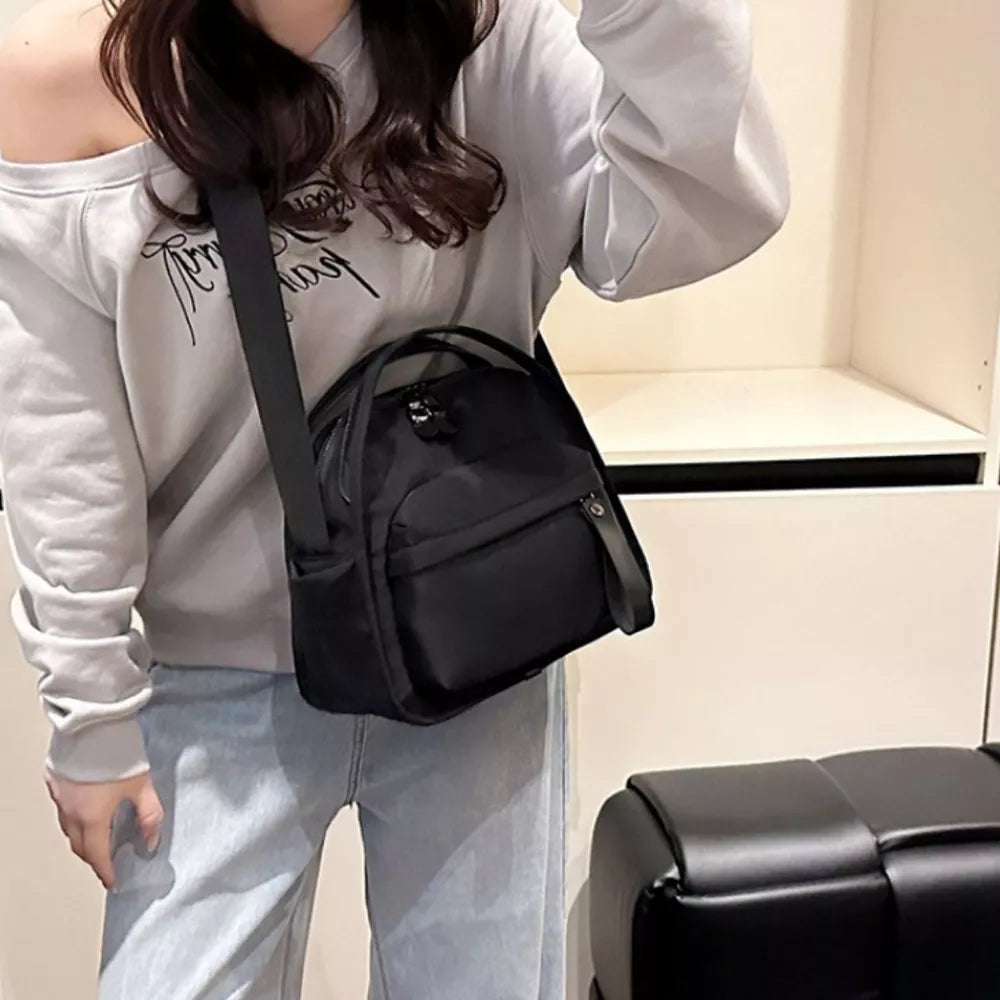Black nylon chest bag with adjustable strap and multiple pockets.