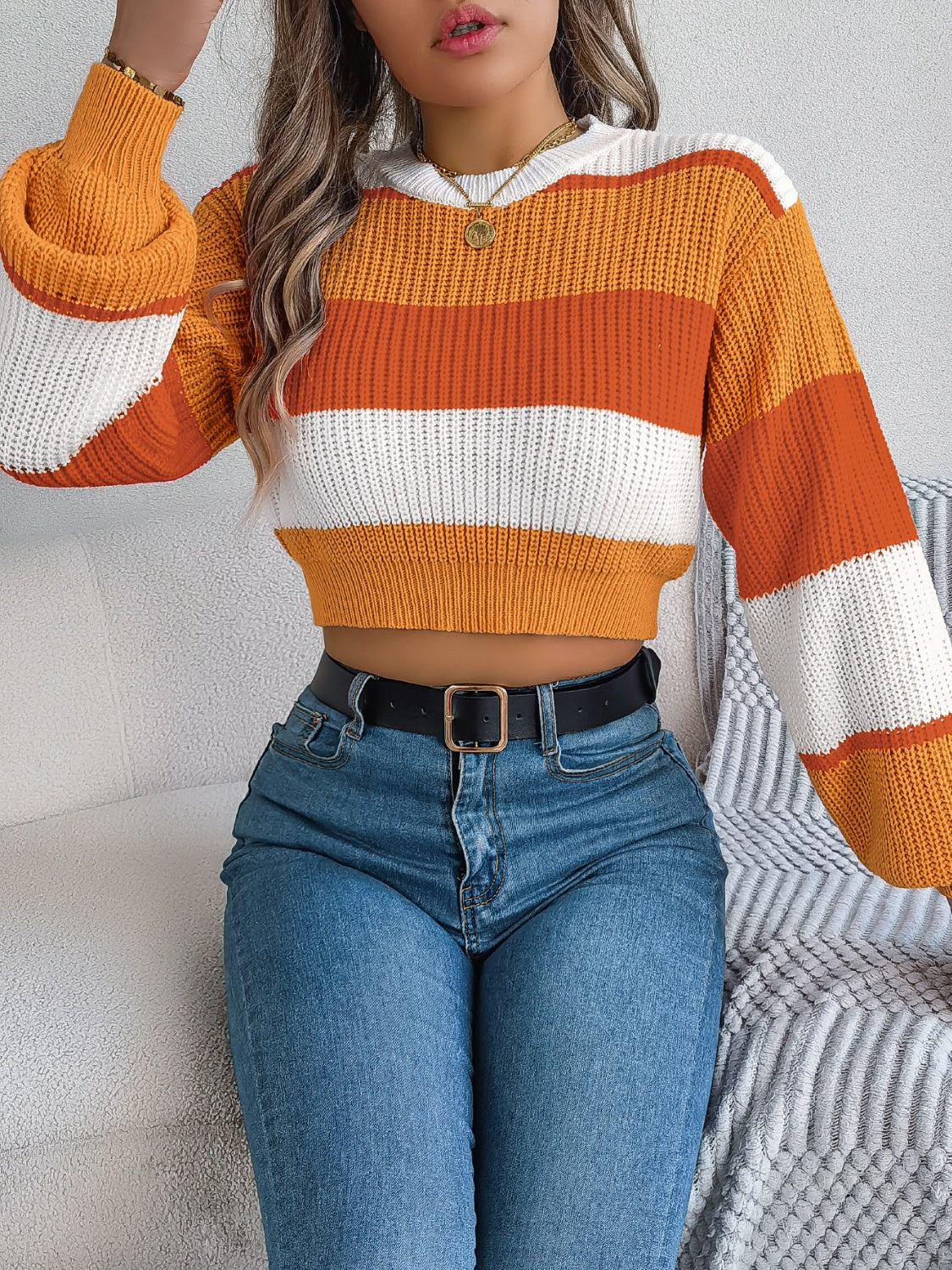 Striped acrylic crop knit sweater with balloon sleeves in tangerine, white, and orange.