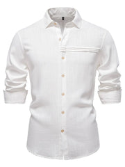White linen button-up shirt with pleated pocket detail and rolled sleeves.
