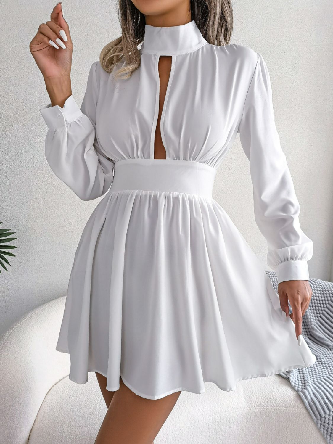 White fit-and-flare mini dress with keyhole neckline, long sleeves, and A-line skirt.