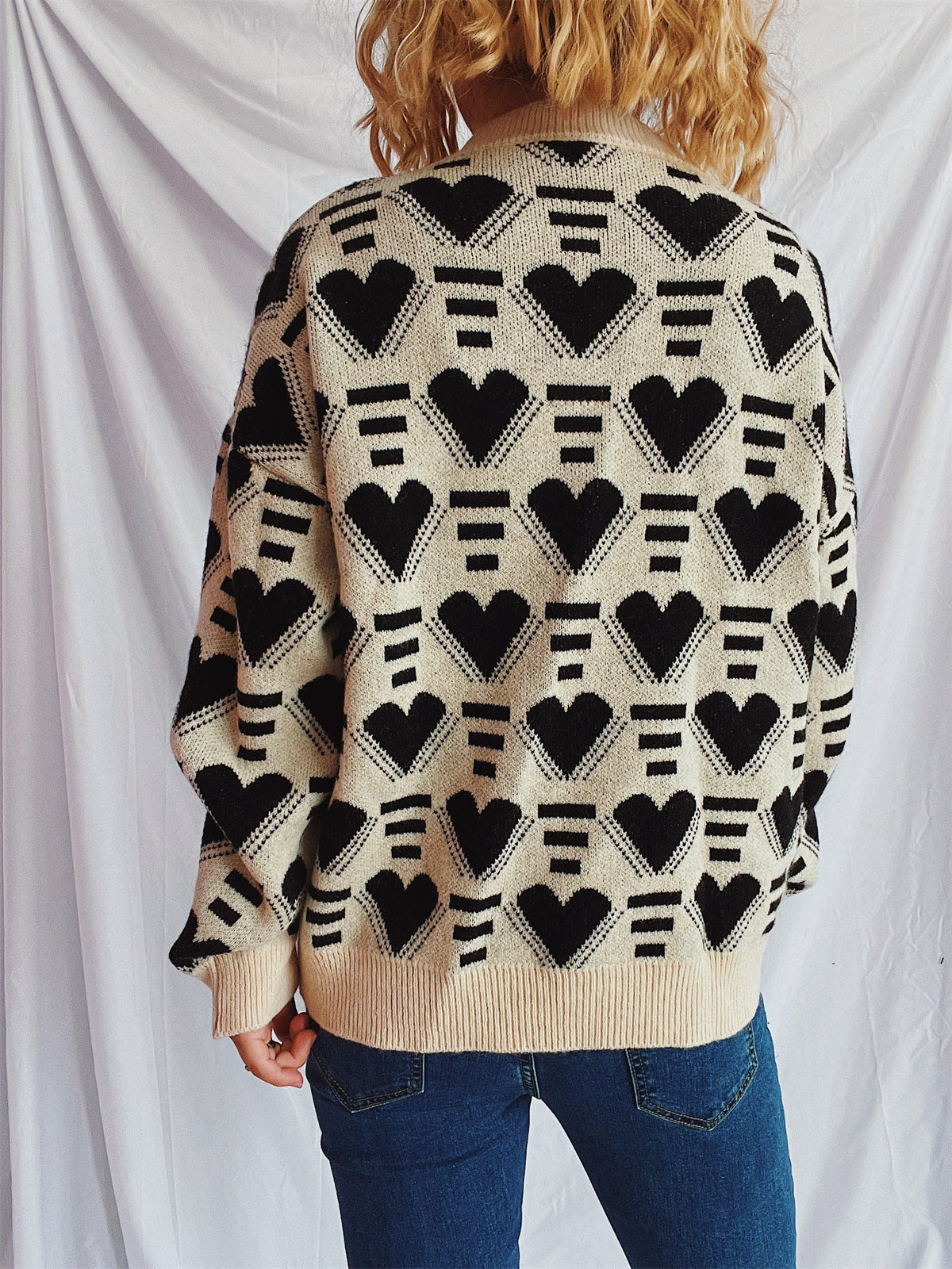 Geometric heart jacquard knit jumper in tan with black hearts and stripes pattern.