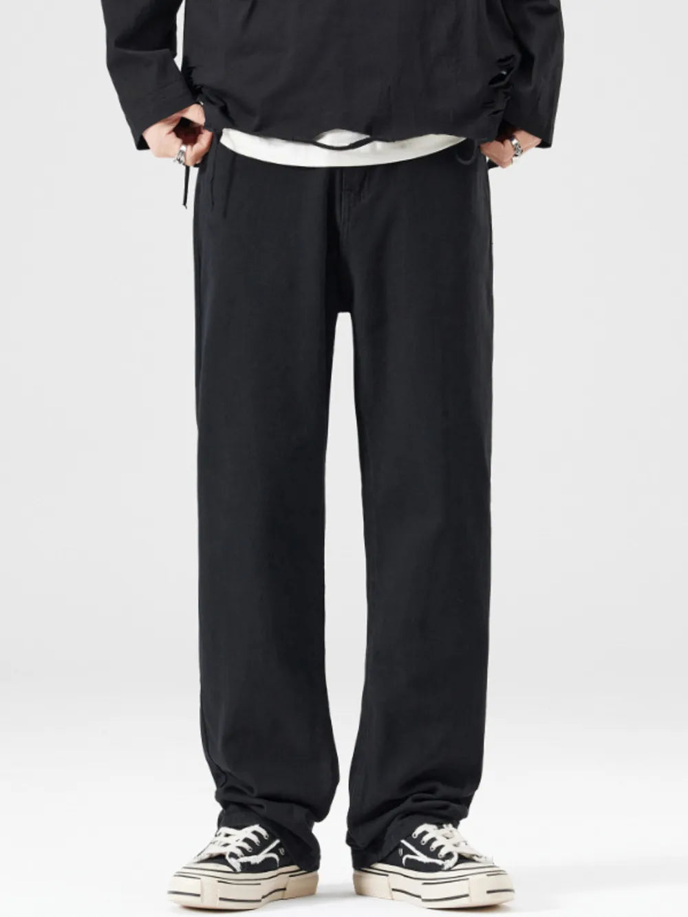 Men's black wide-leg jeans with a relaxed fit, styled with a white t-shirt and sneakers.