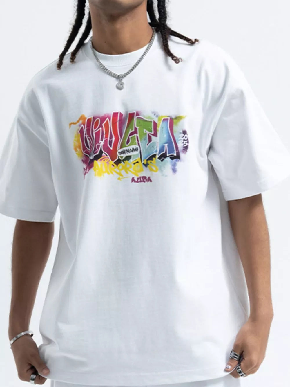 White cotton t-shirt with bold, colorful graffiti graphic print on chest.