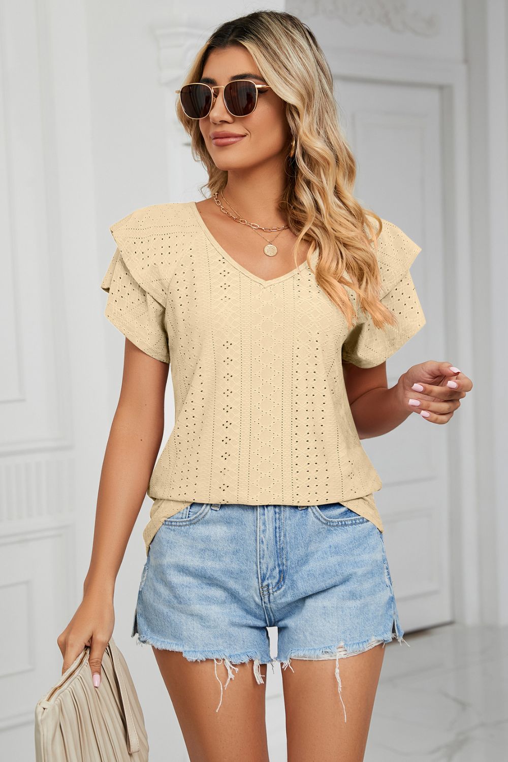Light Yellow eyelet knit v-neck blouse with flutter sleeves and textured pattern.