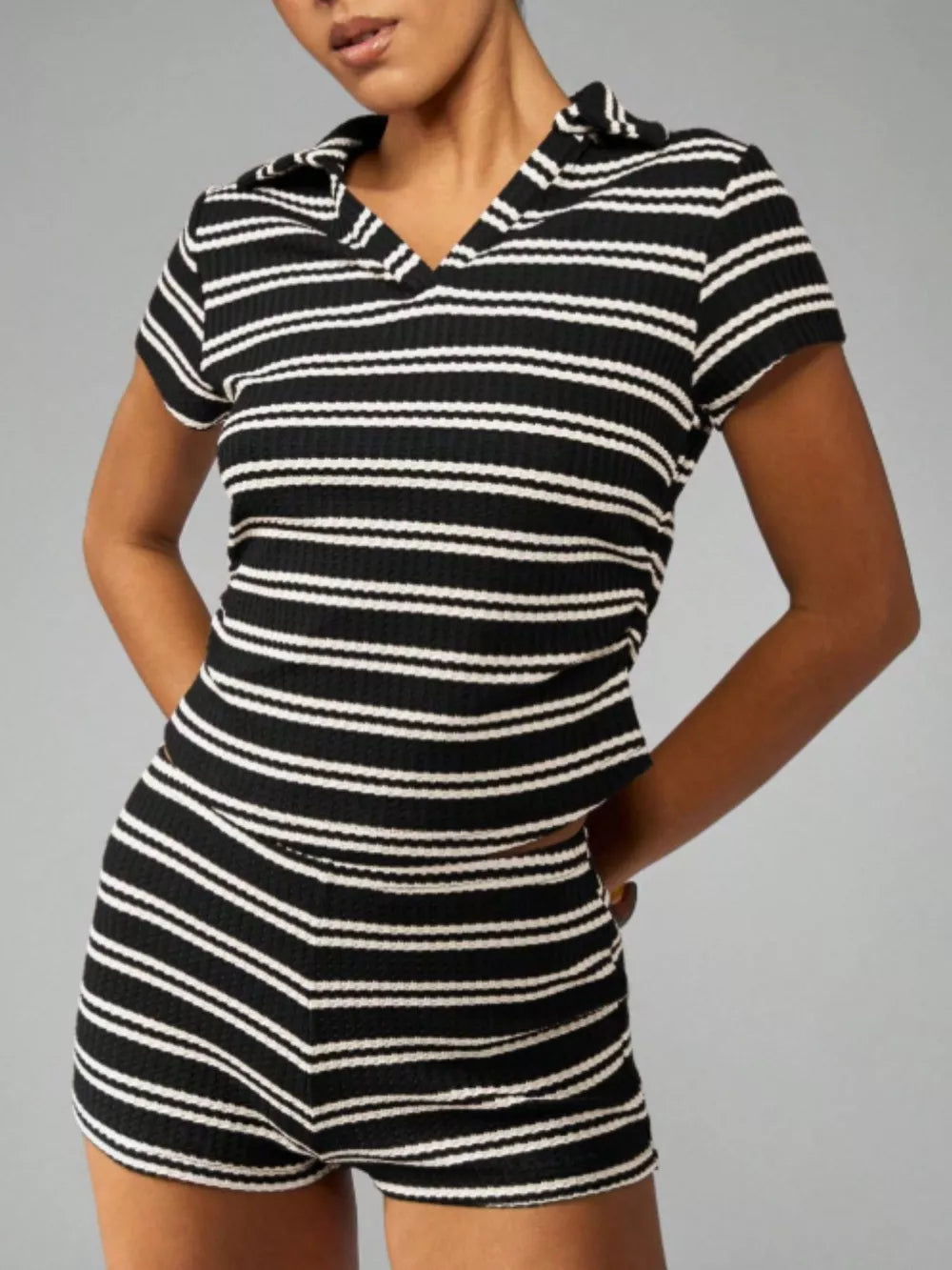 Chic striped knit two-piece set with polo collar top and shorts in black stripes.