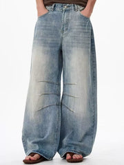 Men's light wash denim wide leg jeans with exaggerated fit and panel details.