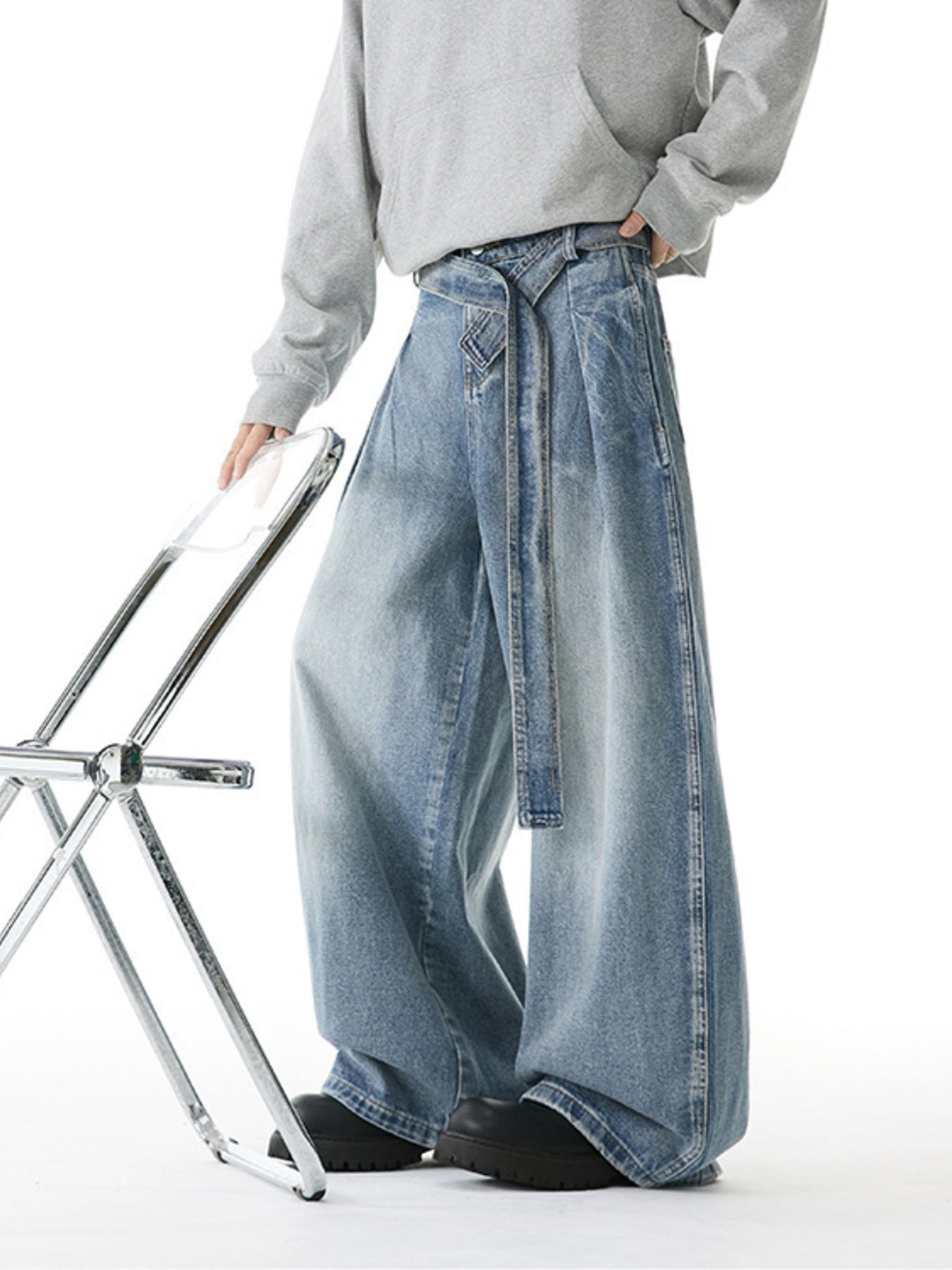 Belted relaxed fit men's light blue denim jeans with a wide leg.