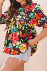 Embroidered floral babydoll blouse with yellow stitching detail and short sleeves.