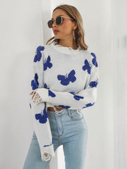White cropped knit sweater with blue butterfly print and distressed details.