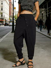 Black pinstripe harem pants with decorative buttons and pockets, cuffed ankles.