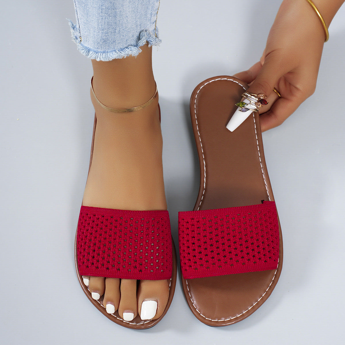 Red perforated comfort slide sandals with brown soles and white stitching.