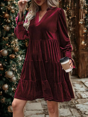 Burgundy velvet tiered mini dress with V-neck and smocked cuffs.