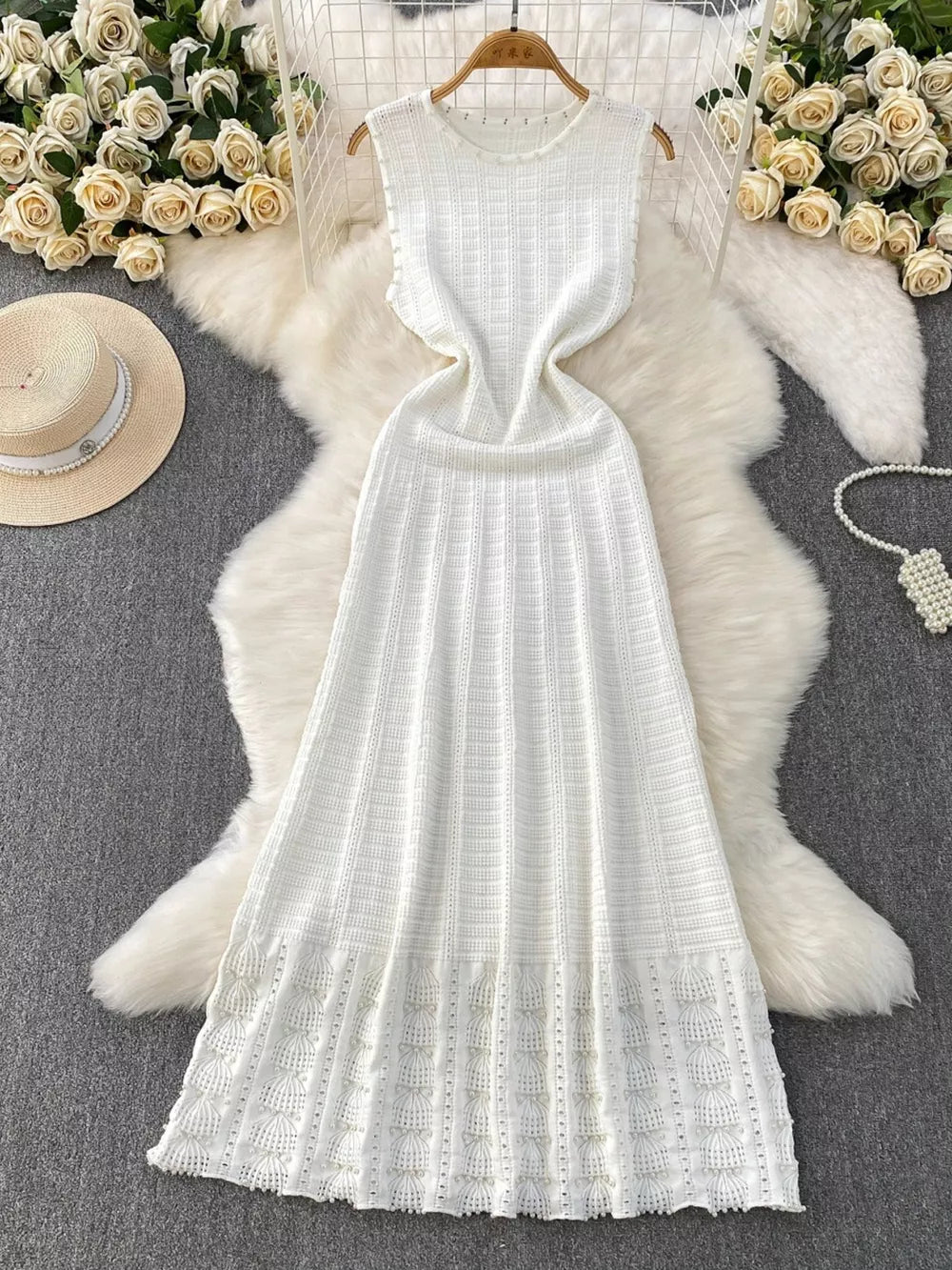 White knit midi dress with cutout details and textured pattern.
