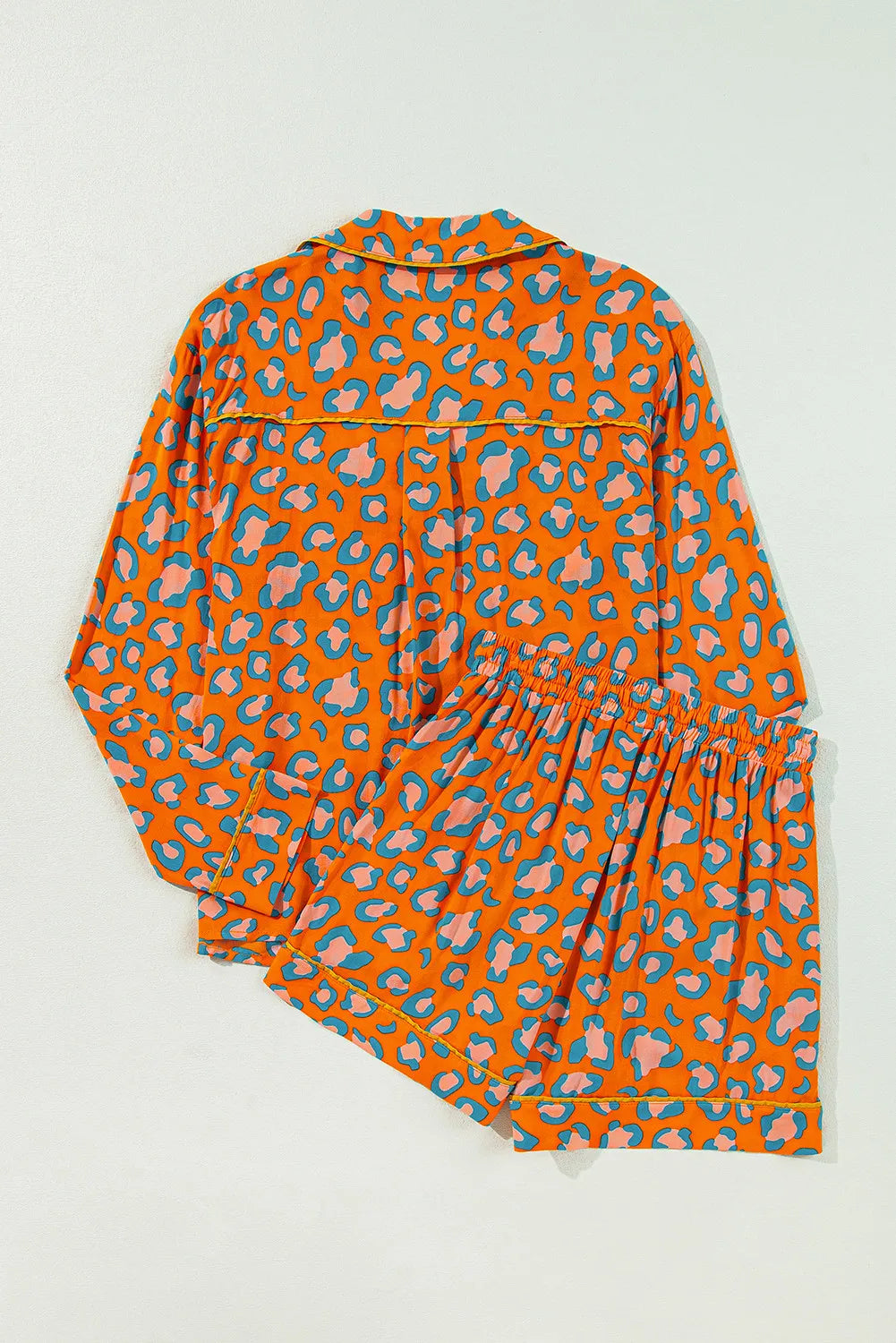 Orange leopard print satin pajama set with collared top and shorts.