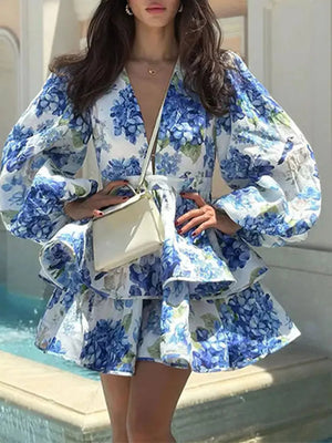 Blooming ruffle layered mini dress in sky blue floral print with V-neck and puff sleeves.