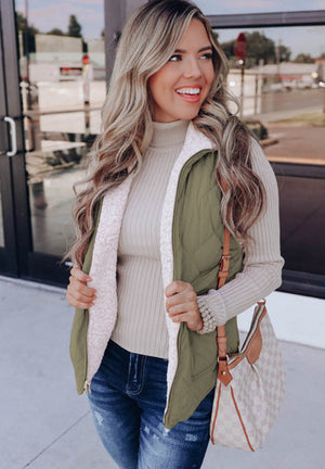 Quilted sherpa-lined utility vest in sage green with a cozy sherpa lining.
