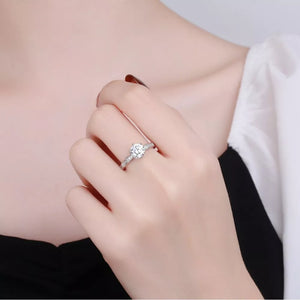 Sterling silver ring with brilliant moissanite center stone and pave band.
