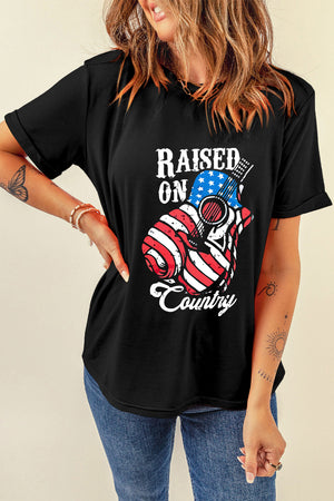 Black graphic t-shirt with American flag guitar and Raised On Country text