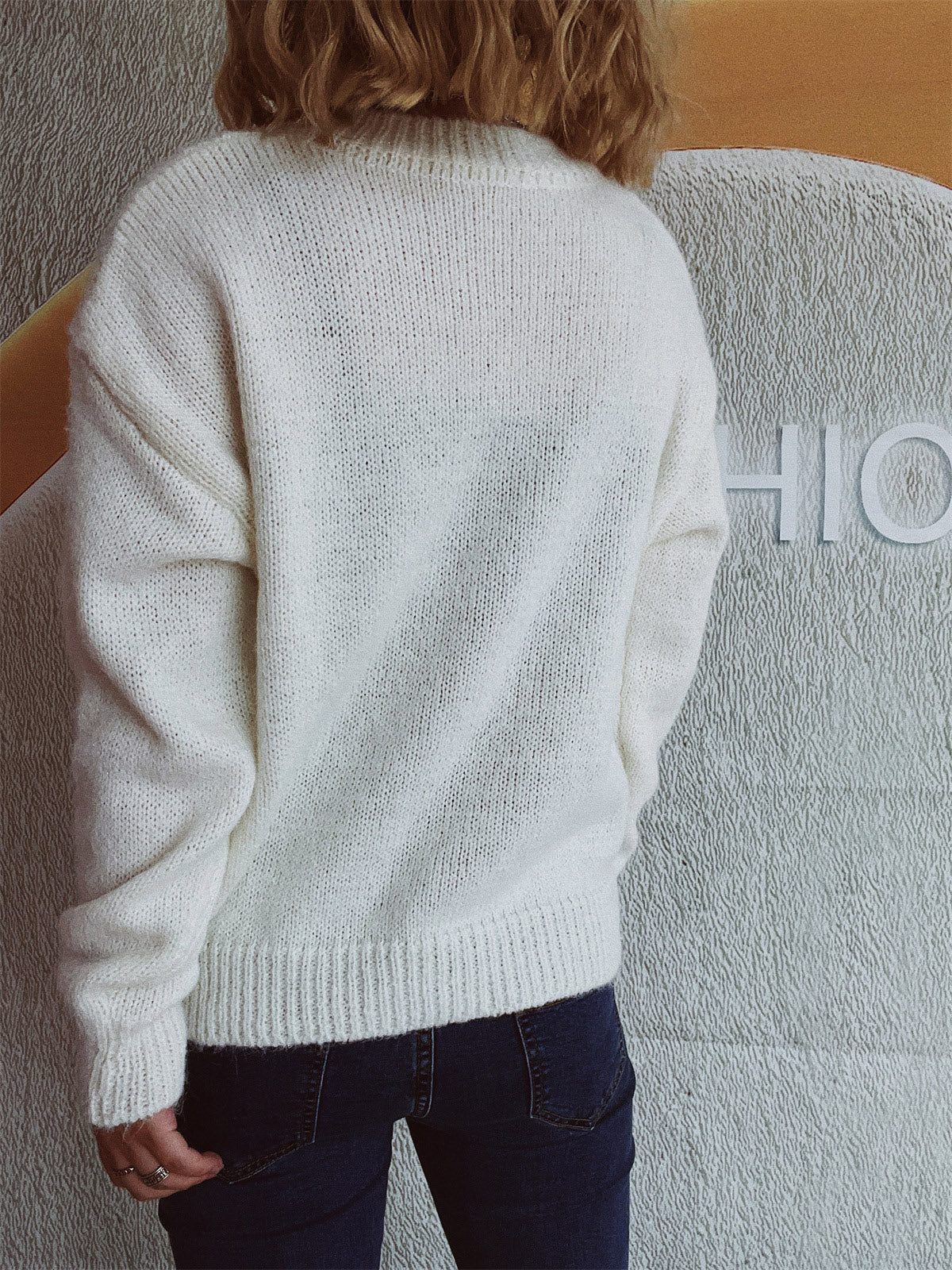 White knit crewneck sweater with ribbed cuffs and hem, crew neckline, and long sleeves.