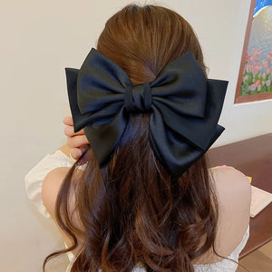 Black satin bow barrette hair clip with alloy accents on brown hair
