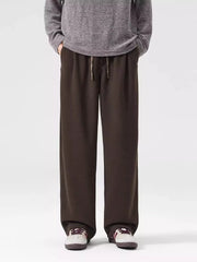 Men's brown loose-fit casual sweatpants with drawstring waist and pockets.