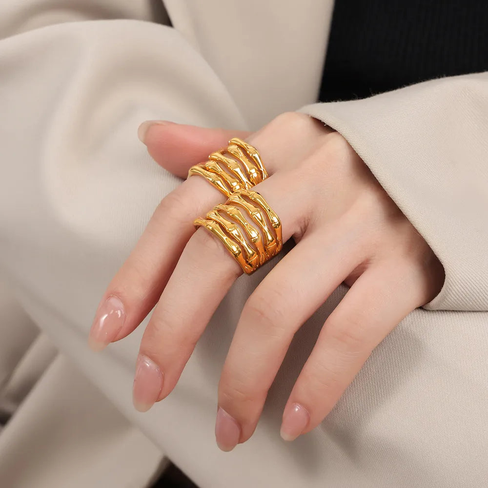 Gold sculptural titanium bamboo ring with layered design on hand