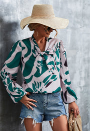 Green abstract print pussy bow blouse with balloon sleeves.