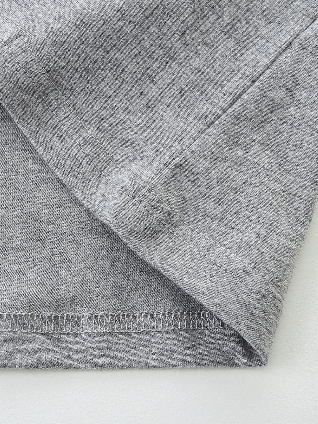 Toddler grey cotton t-shirt detail showing seams and hem.