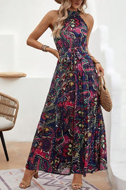 Halter neckline maxi dress with a colorful paisley print and tie waist detail.