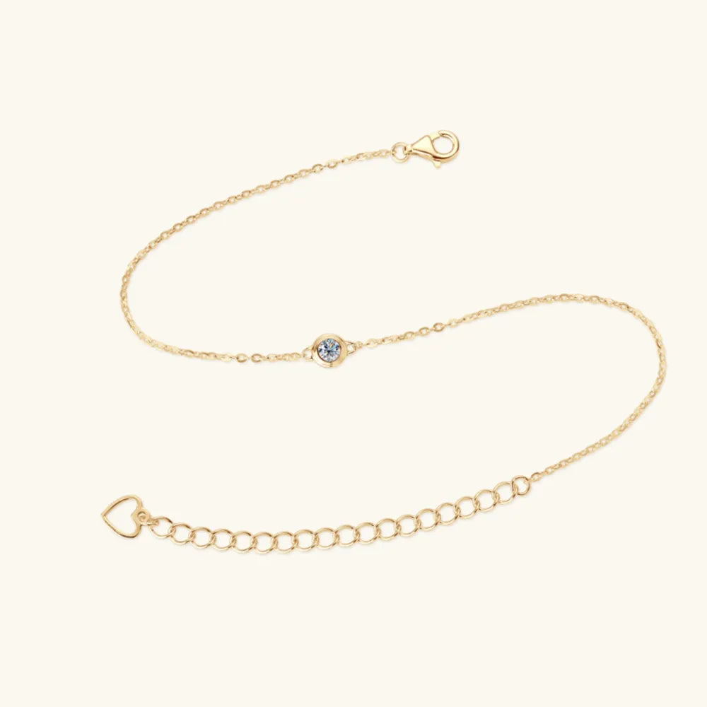 Gold moissanite solitaire chain bracelet with heart charm and adjustable clasp.