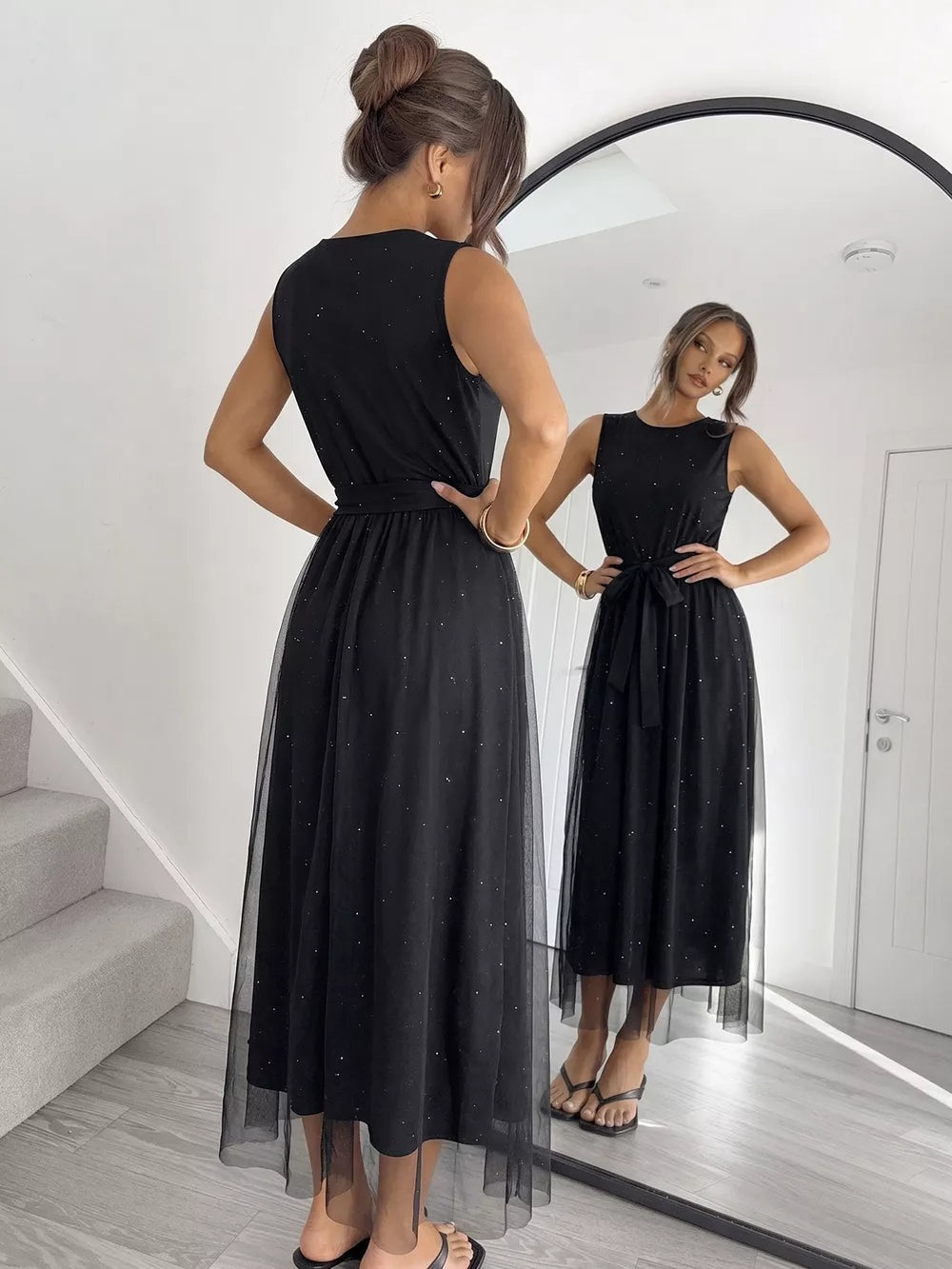 Black glitter tulle midi dress with sleeveless bodice and self-tie belt.