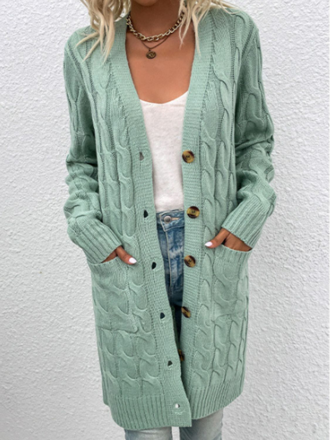 Light Green cable knit button-down cardigan with pockets and brown buttons.