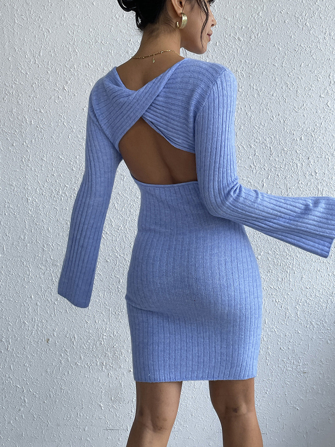 Blue ribbed knit dress with long bell sleeves and a twist back cutout.